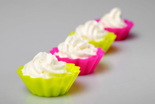 Four portions of whipped cream over white background. 