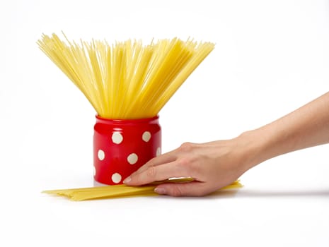 Woman's hand holding red jar full of spaghetti inside.  Isolated on a white background.