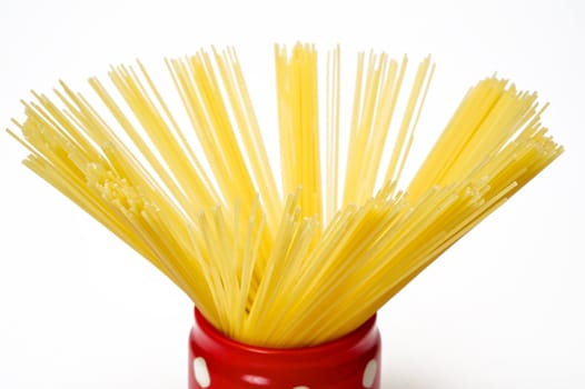 Closeup spaghetti inside a red jar isolated on white background