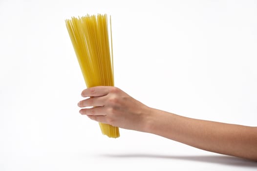 Woman's hand holding bunch of spaghetti.  Isolated on a white background.