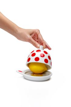 Woman's hand opening bank with lemon inside on a white background