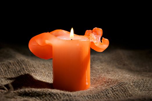 Closeup of a burning candle on the dark background