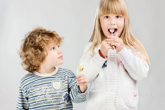 Boy and girl having lollipop