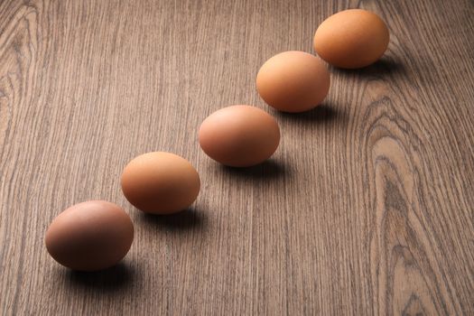 Brown eggs in a line on white background