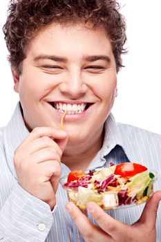 Happy young chubby man with fresh salad, isolated on white