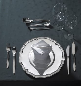 noble place setting with flatware and drinking glasses on a table seen from above