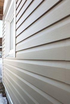 Wall of the house, finished in vinyl siding and window