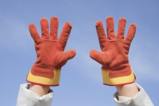 Demonstrated two working gloves against the blue sky