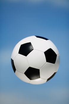 soccer ball on the blue sky background, selective focus on nearest part of ball