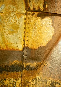 Horizontal background of rusted and grungy metal with visible seams and rivet holes from the side of a naval vessel