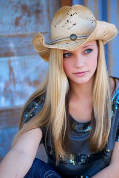 Beautiful, blond, teen model looks pensive as she wears a cowboy hat