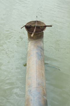 Photo of sewage steel pipe on the water.