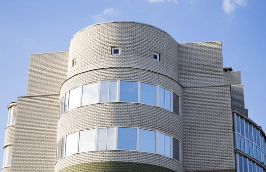 Many-storeyed brick building against the blue sky