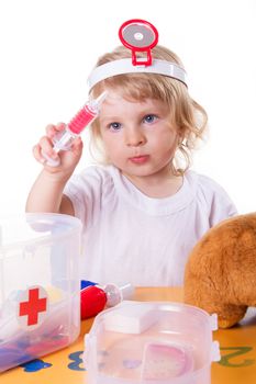 Little girl playing as doctor with syringe on white