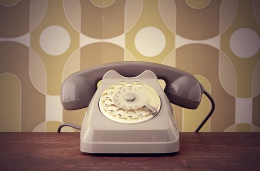 Old-fashioned phone on vintage background