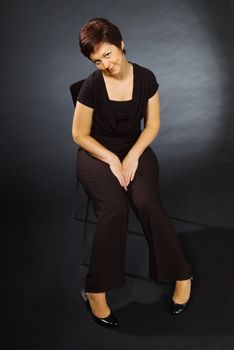 Studio portrait of young woman sitting on chair