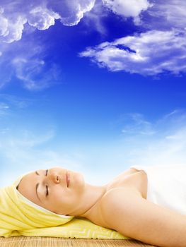 Young woman getting the spa treatment on blue sky