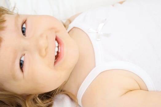 Smiling little girl in a bed