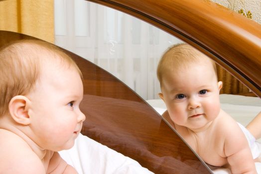 Small baby, looking to a mirror