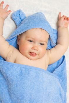 Small smiling baby in blue towel