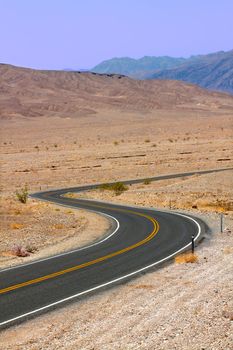 Long winding road through the hot deserts of Death Valley in California.
