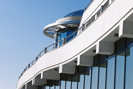 facade of modern building in blue and white tones on a background bright sky