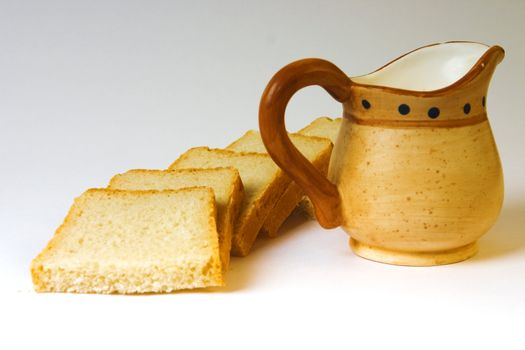 slices of bread and milk jug on a white background