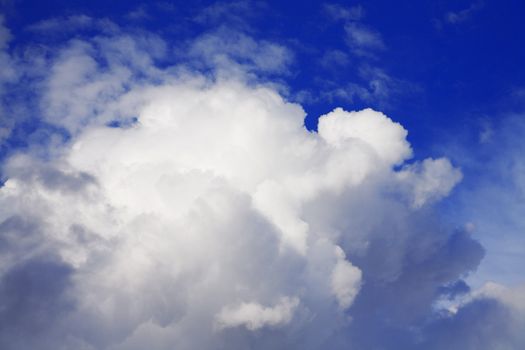 cumulus clouds soaring on the dark blue sky