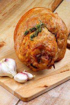 Delicious Roasted Pork Knuckle Glazed with Spices and Garlic closeup on Cutting Board