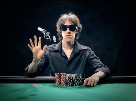 Poker player at a poker table throwing his chips