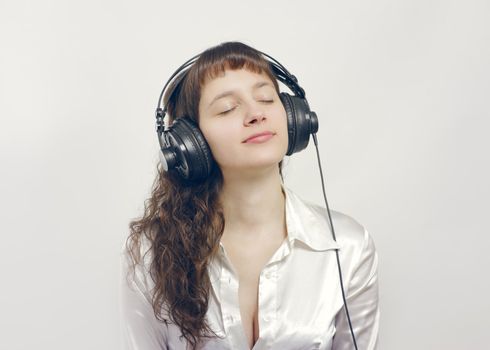 Portrait of a beautiful relaxed young woman enjoying music with eyes closed 
