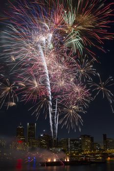 Multi-Color Fireworks Display Over Portland Oregon Skyline Along Willamette River Waterfront at Night