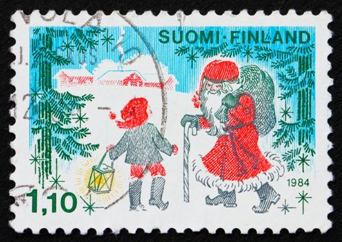 FINLAND - CIRCA 1984: a stamp printed in the Finland shows Father Christmas and a Child, circa 1984