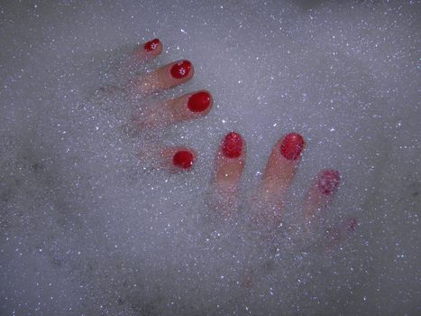 Photo by painted fingernails in the bath foam.