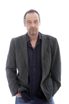 Studio shot of handsome mature man with hands in his pockets
