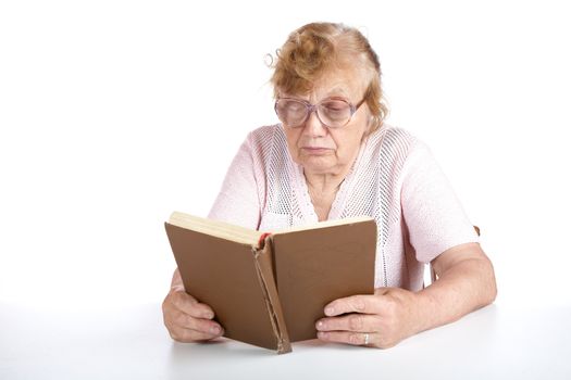 old woman in glasses reads the book on a white background
