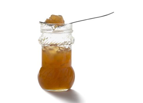 The spoon of jam on glass bank isolated