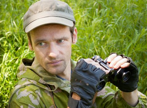 The young man on hunting with the field-glass