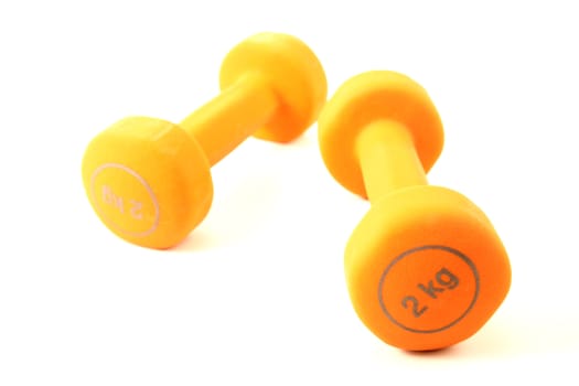 Pair of orange dumbbells isolated on a white background