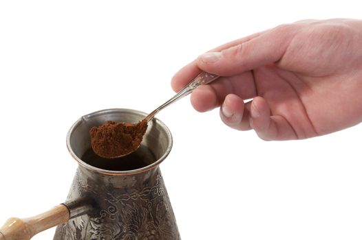 The spoon of ground coffee fallen asleep in a coffee maker on white background