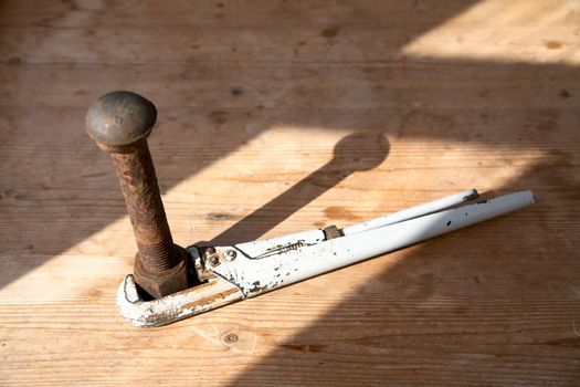 Adjustable spanner and rusty bolt with a nut on  wooden table