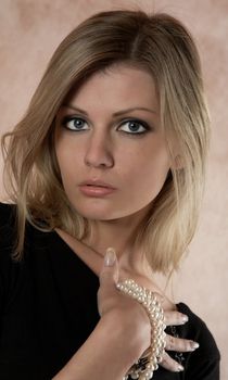 The girl with beads from pearls in a hand