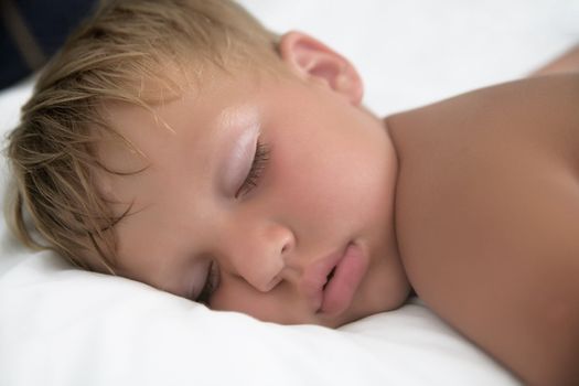 Baby boy sleeping in bed