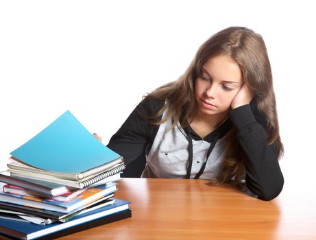 The girl-teenager looks at  pile of books on a white background