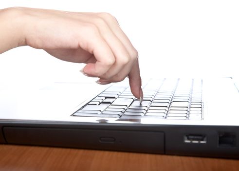 Female hand with a nail on the laptop keyboard