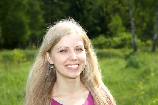 The laughing girl against green wood