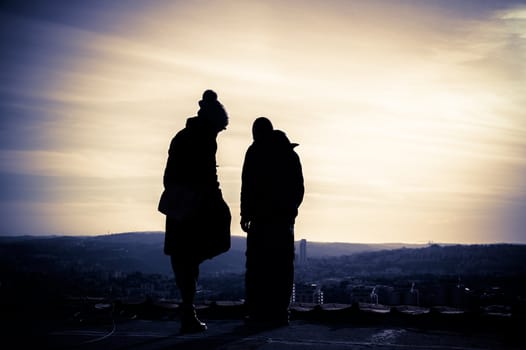 Silhouette of young couple on the rooftop at sunset