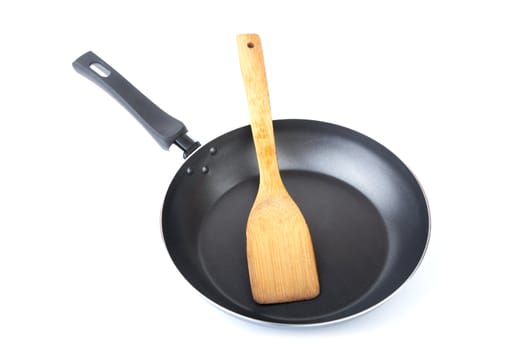 Wooden kitchen shovel in a frying pan on  white background