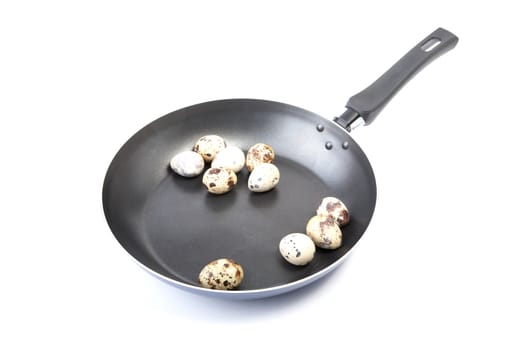 quail eggs in a frying pan on a white background