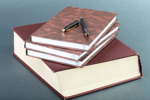 Thick book volume notebooks and pen on a table